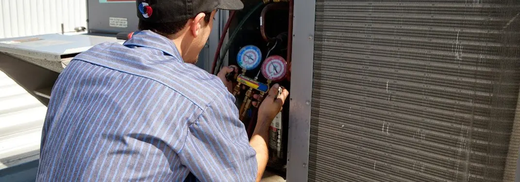 HVAC technician servicing a condenser unit in Maricopa